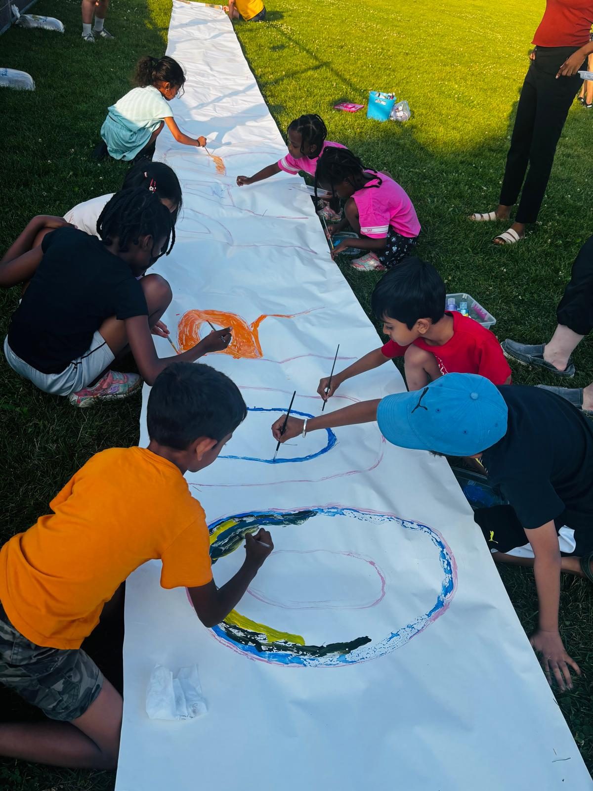Children painting the banner across the field.