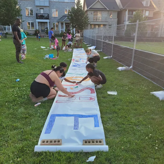 Neighbours and children working on the banner.