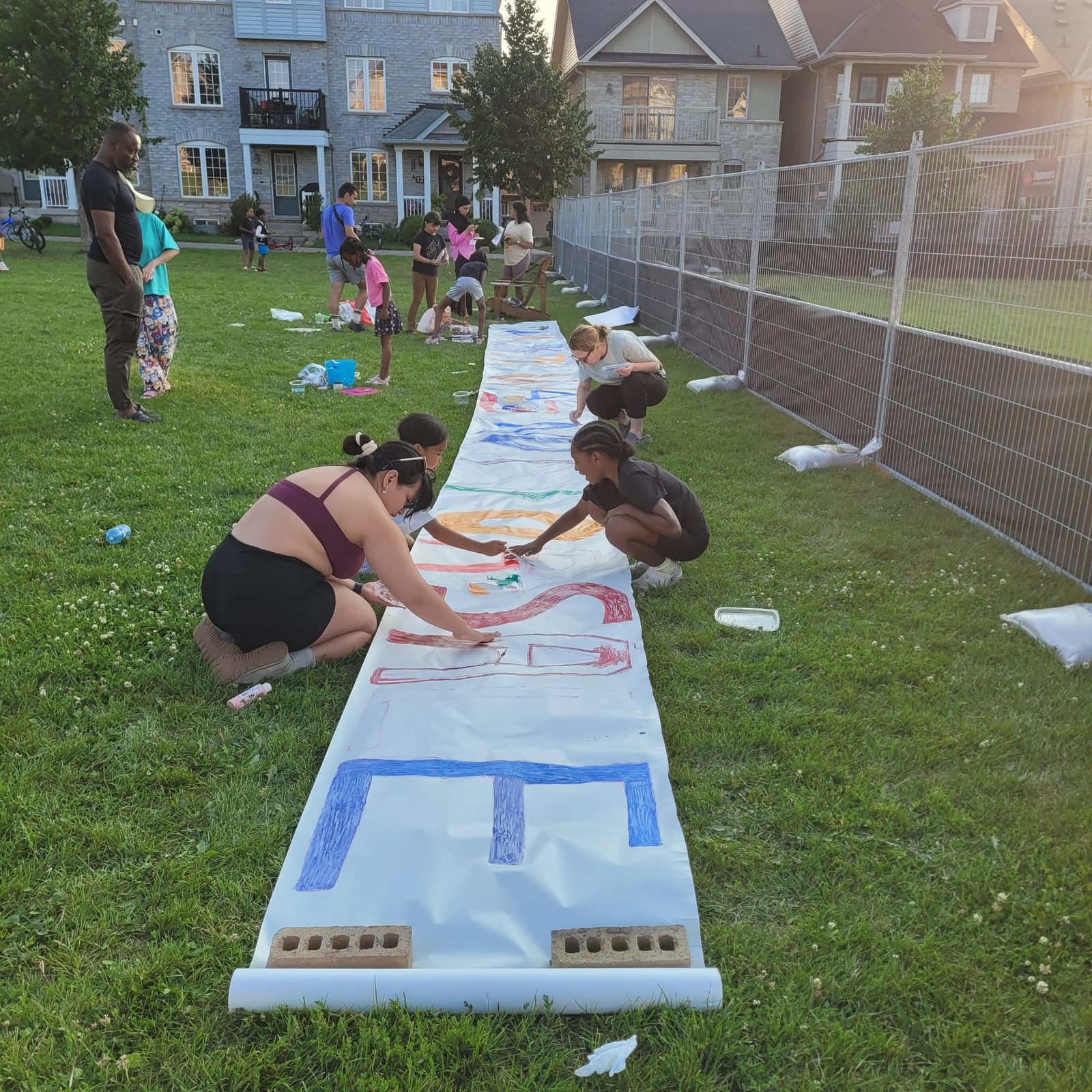 Neighbours and children working on the banner.