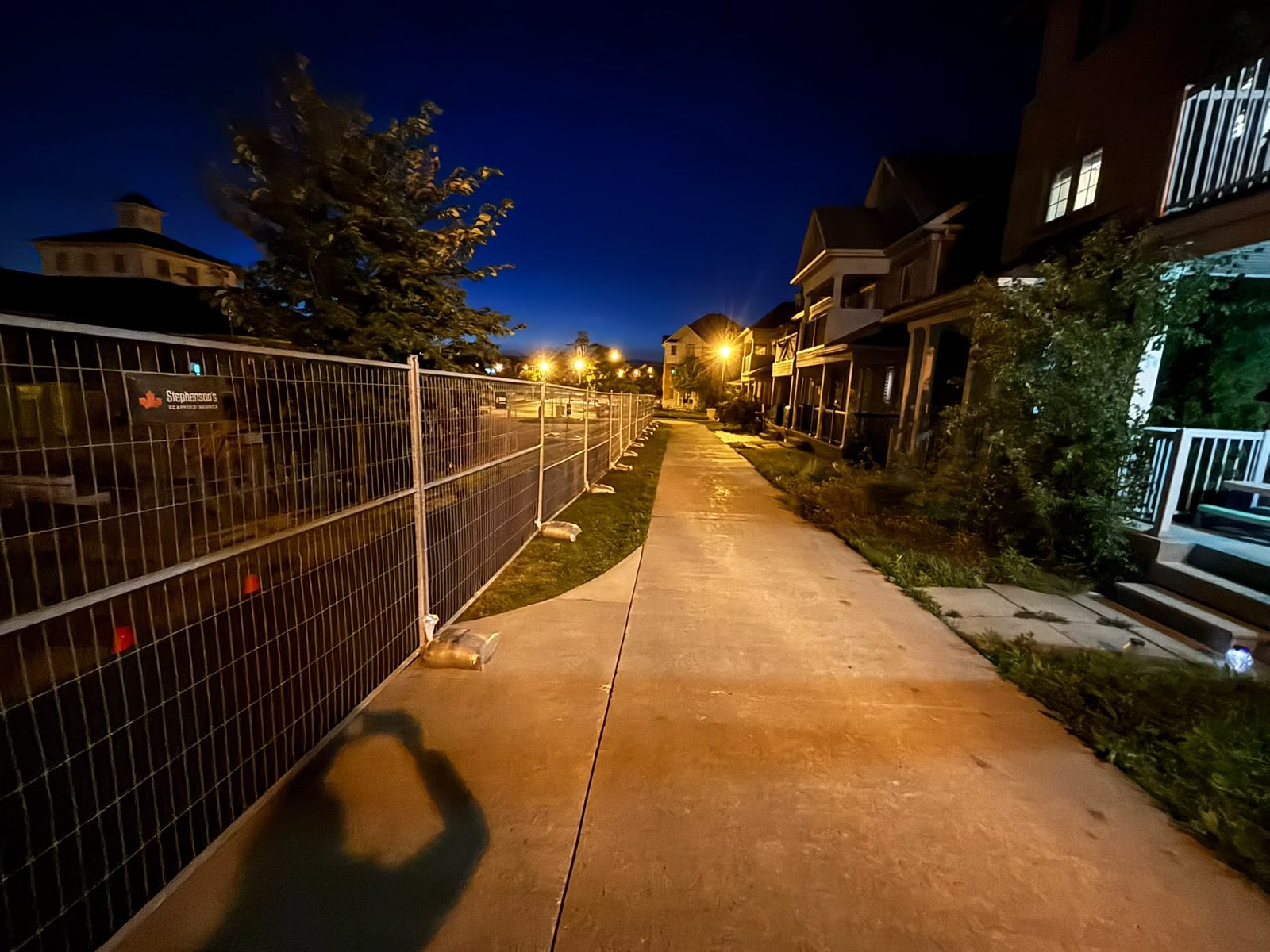 The walking loop at nightfall, fenced off. Fifteen years of daily use, and no plan to reconnect it.